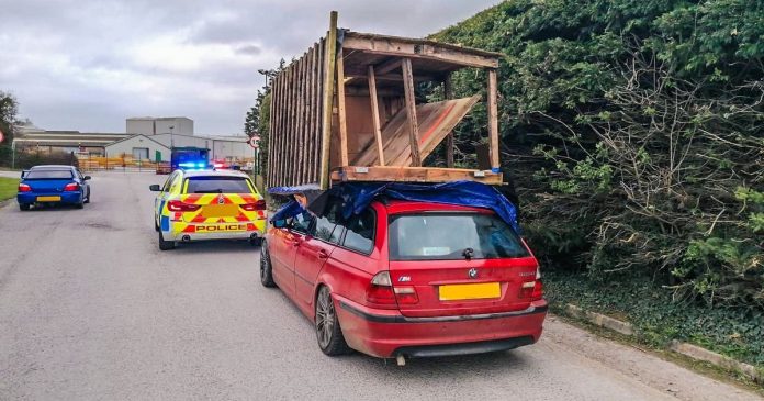 The driver tries a 30 mile drive with a shed on the roof of the car

