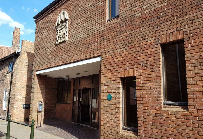 King's Lynn Court said a banned driver was caught driving a car with a missing rear window

