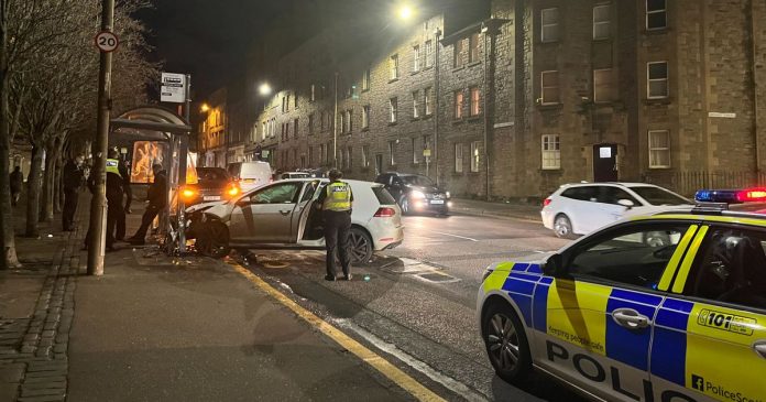 Emergency services rush to the scene in Edinburgh when a car crashes into a bus stop

