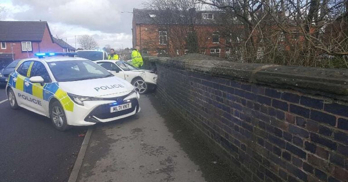 Dramatic pictures show car teetering after smashing through Bolton bridge
